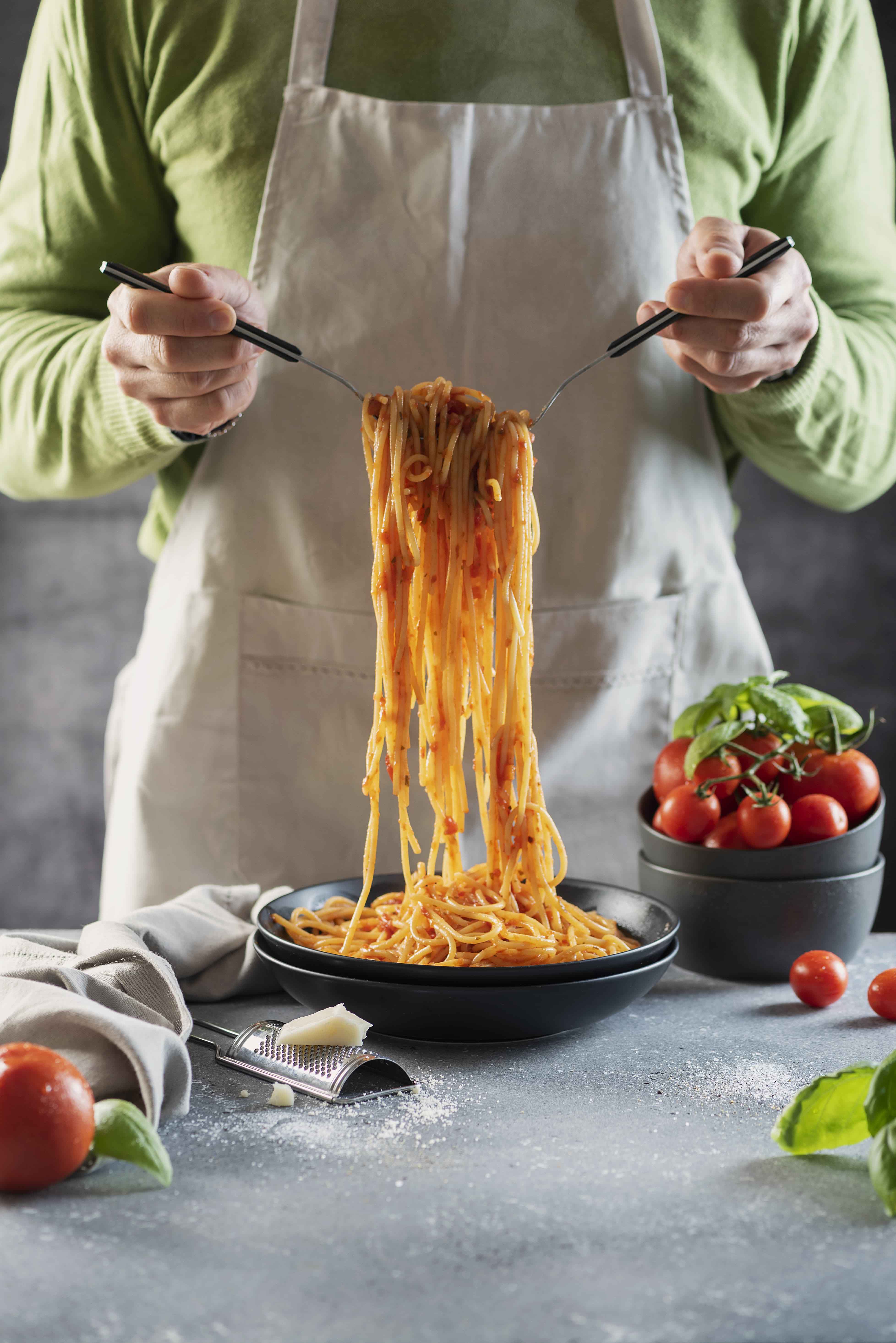 foto di uno chef che impiatta degli spaghetti al pomodoro